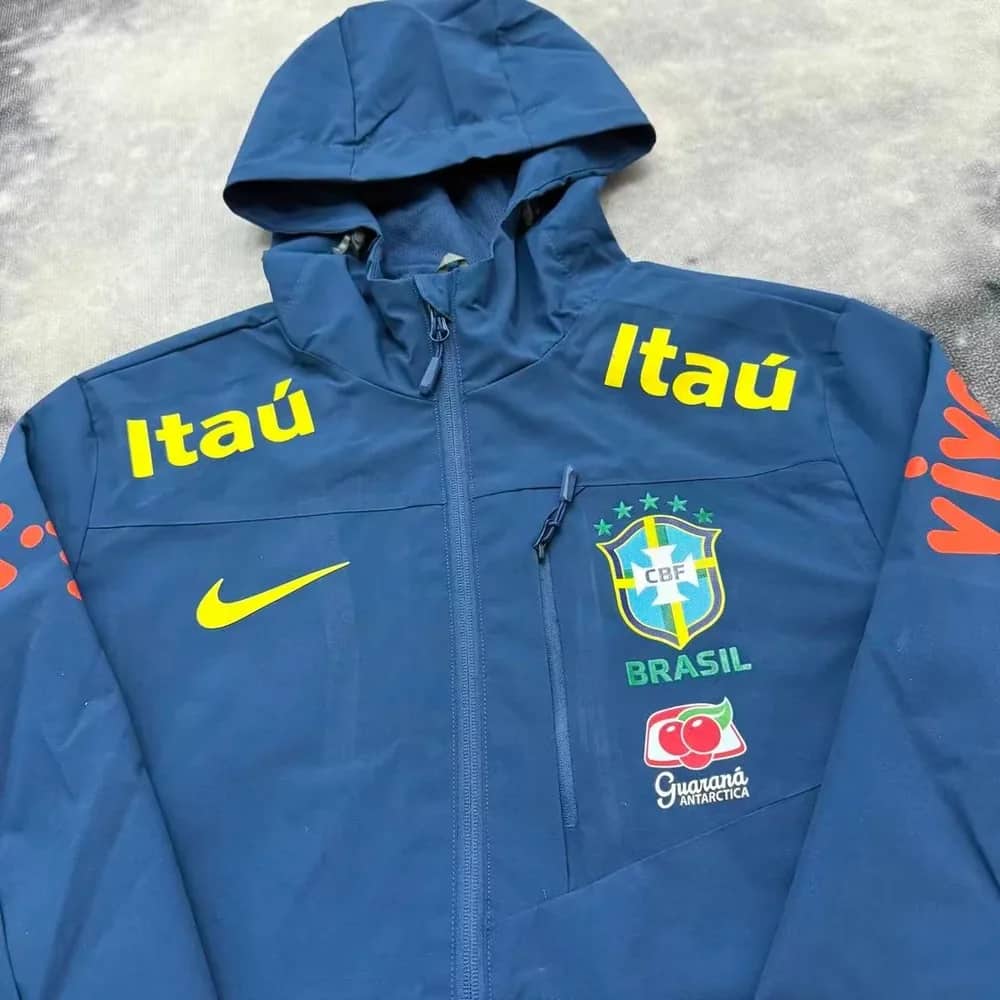 Détail du buste de la veste imperméable du Brésil bleu nuit, poche zippée et inscriptions jaunes